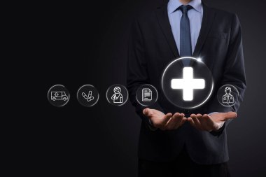 İş adamının elinde sanal ve tıbbi ağ bağlantısı simgeleri var. Covid-19 salgını insanları bilinçlendirir ve sağlık hizmetlerine dikkat çeker. Doktor, belge, ilaç, ambulans, hasta ikonu