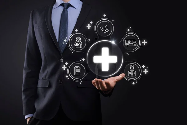 Businessman hold virtual plus medical network connection icons. Covid-19 pandemic develop people awareness and spread attention on their healthcare.Doctor,document,medicine,ambulance,patient icon