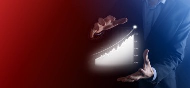 Holografik grafikler ve borsa istatistikleri tutan işadamı kâr elde ediyor. Büyüme planlama ve iş stratejisi kavramı. İyi ekonomi formunun dijital ekran görüntüsü