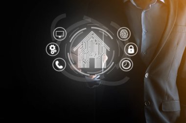 İş adamı ev ikonunu tutuyor. Marketin ev kontrollü, akıllı ev ve ev otomasyon uygulaması konsepti. PCB tasarımı ve akıllı telefonu olan kişi. Yenilik teknolojisi internet ağı kavramı