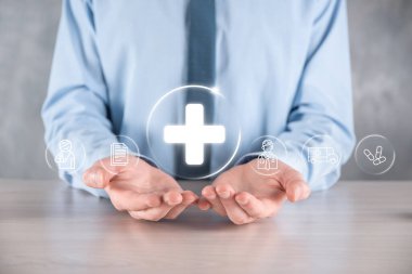 İş adamının elinde sanal ve tıbbi ağ bağlantısı simgeleri var. Covid-19 salgını insanları bilinçlendirir ve sağlık hizmetlerine dikkat çeker. Doktor, belge, ilaç, ambulans, hasta ikonu