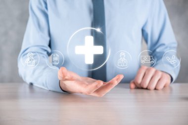 İş adamının elinde sanal ve tıbbi ağ bağlantısı simgeleri var. Covid-19 salgını insanları bilinçlendirir ve sağlık hizmetlerine dikkat çeker. Doktor, belge, ilaç, ambulans, hasta ikonu