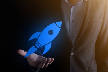 Soyut dijital roket ikonu taşıyan iş adamı konsepti fırlatılıyor ve yükseliyor.