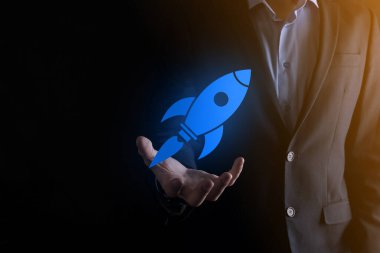 Soyut dijital roket ikonu taşıyan iş adamı konsepti fırlatılıyor ve yükseliyor.