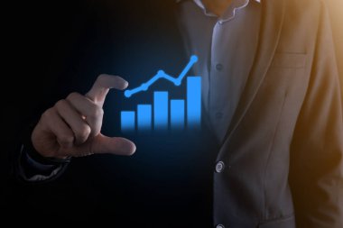 İş adamı elinde pozitif kar artışı olan bir grafik tutuyor. Grafik büyümesi ve grafik artışı işlerinde olumlu göstergeler. Daha kârlı ve büyüyen