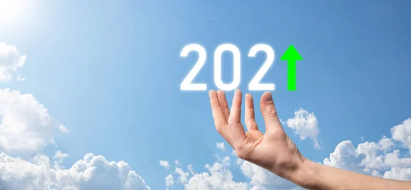 2021年をポジティブなアイコンで空を背景に掲げ 2021年の事業成長を計画 ビジネスマンの計画と彼のビジネスにおける積極的な指標の増加 ビジネスコンセプトの成長 — ストック写真