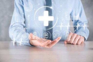 İş adamının elinde sanal ve tıbbi ağ bağlantısı simgeleri var. Covid-19 salgını insanları bilinçlendirir ve sağlık hizmetlerine dikkat çeker. Doktor, belge, ilaç, ambulans, hasta ikonu