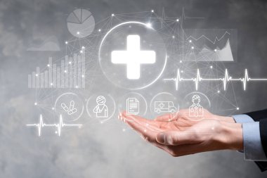 İş adamının elinde sanal ve tıbbi ağ bağlantısı simgeleri var. Covid-19 salgını insanları bilinçlendirir ve sağlık hizmetlerine dikkat çeker. Doktor, belge, ilaç, ambulans, hasta ikonu