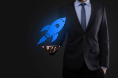 Soyut dijital roket ikonu taşıyan iş adamı konsepti fırlatılıyor ve yükseliyor.