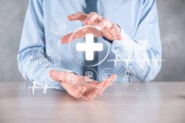 İş adamının elinde sanal ve tıbbi ağ bağlantısı simgeleri var. Covid-19 salgını insanları bilinçlendirir ve sağlık hizmetlerine dikkat çeker. Doktor, belge, ilaç, ambulans, hasta ikonu