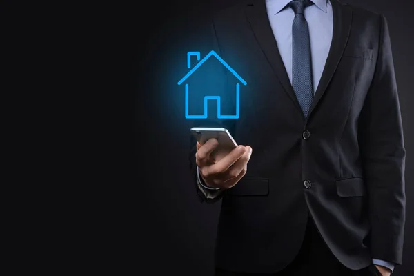 Real estate concept, businessman holding a house icon.House on Hand.Property insurance and security concept. Protecting gesture of man and symbol of house