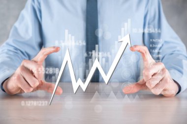 İş adamı satış verilerini ve ekonomik büyüme grafiğini elinde tutuyor. İş planlama ve strateji. Takas ticareti analiz ediliyor. Finansal ve bankacılık. Teknoloji dijital pazarlama. Kâr ve büyüyen plan.