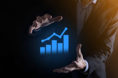 İş adamı elinde pozitif kar artışı olan bir grafik tutuyor. Grafik büyümesi ve grafik artışı işlerinde olumlu göstergeler. Daha kârlı ve büyüyen