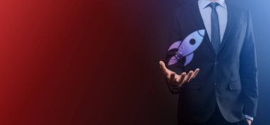 Boş bir iş. Siyah arka planda takım elbiseli bir işadamı ellerini koruyucu bir şekilde tutar. Bakım ve himaye jesti.