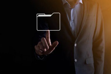 İş adamı dizin simgesini tutuyor. Belge Yönetim Sistemi veya modern bilgisayar bilişim danışmanı tarafından kurulmuş DMS yönetici dosyaları ve kurumsal dosyaları arıyor. İş işleme