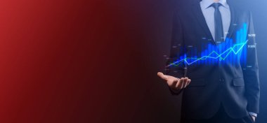 Holografik grafikler ve borsa istatistikleri tutan işadamı kâr elde ediyor. Büyüme planlama ve iş stratejisi kavramı. İyi ekonomi formunun dijital ekran görüntüsü