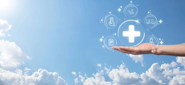 Businessman hold virtual plus medical network connection icons. Covid-19 pandemic develop people awareness and spread attention on their healthcare.Doctor,document,medicine,ambulance,patient icon