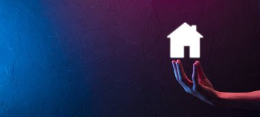 Emlak konsepti, iş adamı ev ikonu tutuyor. Ev elden gidiyor. Emlak sigortası ve güvenlik kavramı. İnsanın jestini ve evin sembolünü koruyorum..