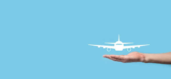 Male hand holding plane airplane icon on blue background. Banner.nline ticket purchase.Travel icons about travel planning, transportation, hotel, flight and passport.Flight ticket booking concept