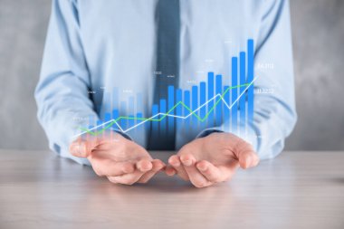 İş adamı elinde pozitif kar artışı olan bir grafik tutuyor. Grafik büyümesi ve grafik artışı işlerinde olumlu göstergeler. Daha kârlı ve büyüyen.