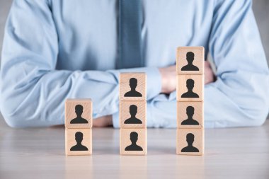 İşadamı, gri masanın üzerine tahta küp şeklini ve kullanıcı simgesini koydu. Mesaj için yer var. İnternet simgeleri arayüzü önplanı. küresel ağ medya kavramı, sanal ekranlarda iletişim, kopyalama alanı.