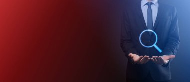 İş adamı ve adam el ele tutuşup cam ikonunu büyütüyorlar. İş dünyası, teknoloji ve internet kavramı.