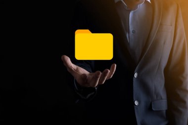 İş adamı dizin simgesini tutuyor. Belge Yönetim Sistemi veya modern bilgisayar bilişim danışmanı tarafından kurulmuş DMS yönetici dosyaları ve kurumsal dosyaları arıyor. İş işleme