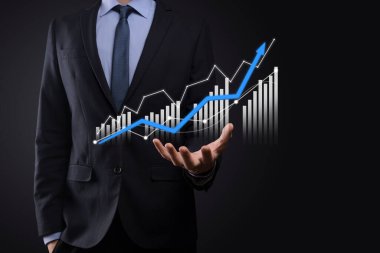 Holografik grafikler ve borsa istatistikleri tutan işadamı kâr elde ediyor. Büyüme planlama ve iş stratejisi kavramı. İyi ekonomi formunun dijital ekran görüntüsü
