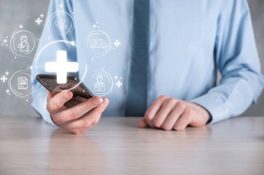 İş adamının elinde sanal ve tıbbi ağ bağlantısı simgeleri var. Covid-19 salgını insanları bilinçlendirir ve sağlık hizmetlerine dikkat çeker. Doktor, belge, ilaç, ambulans, hasta ikonu