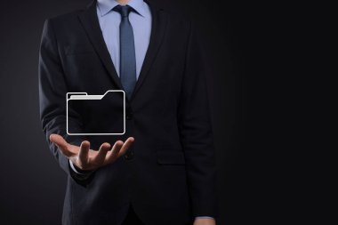 İş adamı dizin simgesini tutuyor. Belge Yönetim Sistemi veya modern bilgisayar bilişim danışmanı tarafından kurulmuş DMS yönetici dosyaları ve kurumsal dosyaları arıyor. İş işleme
