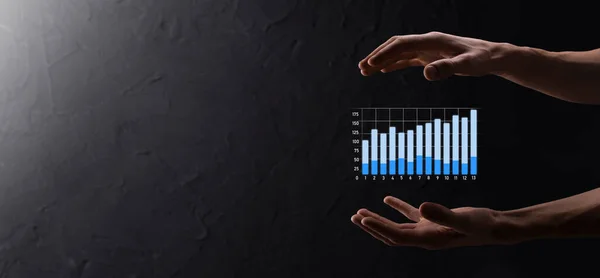 Businessman holding graph growth and increase of chart positive indicators in his business.Investment up concept.analyzing sales data and economic,strategy and planning, Digital marketing and stock market.