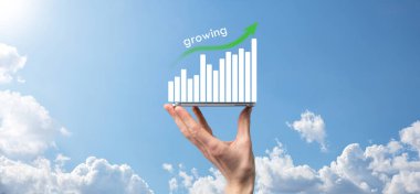 Holografik grafikler ve borsa istatistikleri tutan işadamı kâr elde ediyor. Büyüme planlama ve iş stratejisi kavramı. İyi ekonomi formunun dijital ekran görüntüsü.