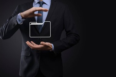 İş adamı dizin simgesini tutuyor. Belge Yönetim Sistemi veya modern bilgisayar bilişim danışmanı tarafından kurulmuş DMS yönetici dosyaları ve kurumsal dosyaları arıyor. İş işleme