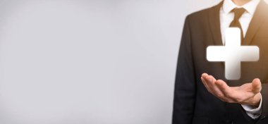 İş adamı elinde 3D artı simge tutuyor, elinde tuttuğu adam kar, fayda, gelişme, artı işareti ile temsil edilen CSR gibi olumlu şeyler öneriyor..