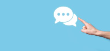 Elinde mesaj ikonu tutan bir iş adamı, elinde baloncuklu konuşma tebligat işareti var. Sohbet simgesi, SMS simgesi, yorum simgesi, konuşma baloncukları.