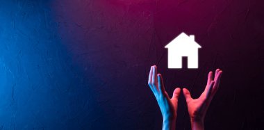 Emlak konsepti, iş adamı ev ikonu tutuyor. Ev elden gidiyor. Emlak sigortası ve güvenlik kavramı. İnsanın jestini ve evin sembolünü koruyorum..