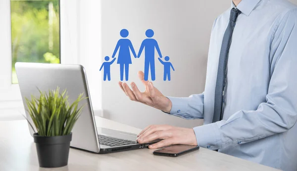 Hand hold young family icon. Family life insurance,supporting and services,family policy and supporting families concepts.Happy family concept.Copy space.mancupped hands showing paper man family.