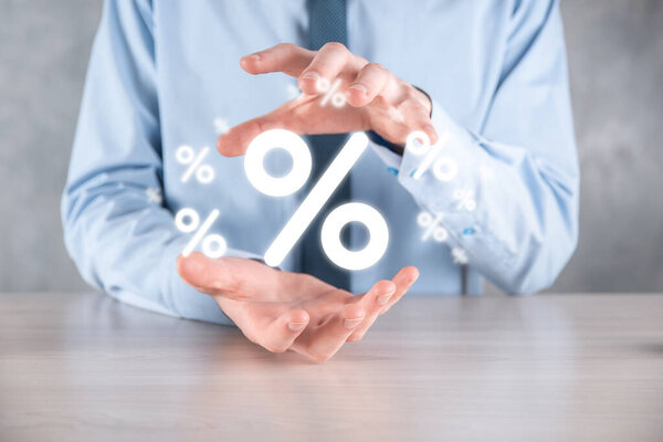 Мужчина держит значок процентной ставки на синем фоне. Процентная ставка Финансовые и ипотечные ставки Concept.Banner с копировальным пространством.