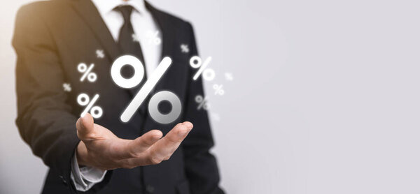 Мужчина держит значок процентной ставки на синем фоне. Процентная ставка Финансовые и ипотечные ставки Concept.Banner с копировальным пространством.