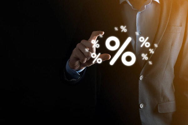 Мужчина держит значок процентной ставки на синем фоне. Процентная ставка Финансовые и ипотечные ставки Concept.Banner с копировальным пространством.