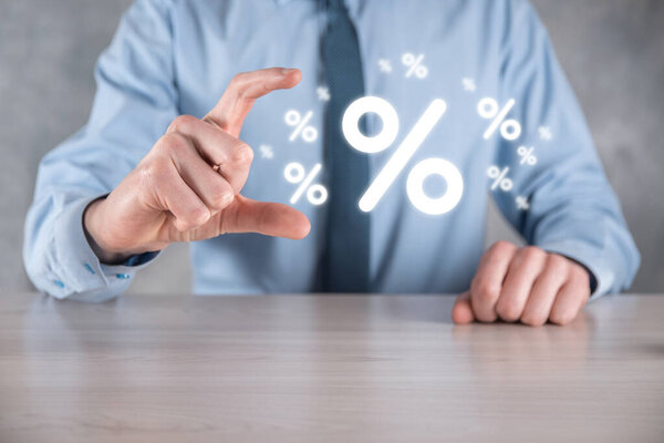 Мужчина держит значок процентной ставки на синем фоне. Процентная ставка Финансовые и ипотечные ставки Concept.Banner с копировальным пространством.