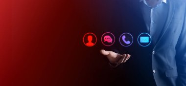 İş adamı el ele tutuşması, ikon telefona, postaya, telefona, telefona, mesaja, iletiye ve kişiye, kullanıcıya basmak. Müşteri hizmetleri çağrı merkezi bizimle konsept bağlantı kurar. Banner, kopyalama alanı. İletişim Yöntemleri