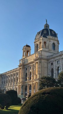 03.12.2025 Viyana: Viyana 'daki tarihi Kunsthistorisches Müzesi, parlak mavi gökyüzü altında güneş ışığıyla klasik mimarisini ve manzaralı bahçesini aydınlatıyor.