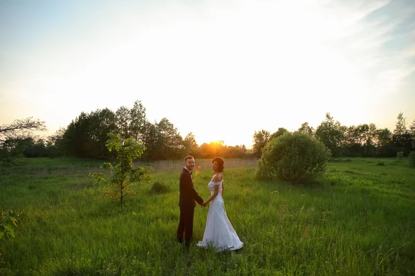 Mariée heureuse et marié au coucher du soleil — Photo