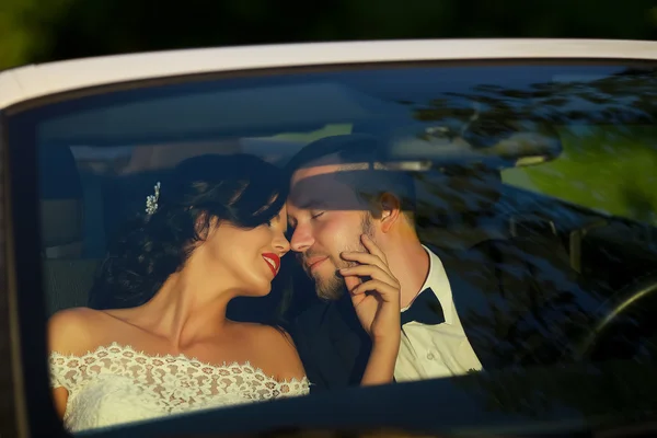 Mariée et marié baisers dans la voiture — Photo