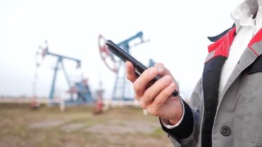 Üniformalı bir adamın, petrol pompasının arka planına karşı yakın plan fotoğrafı.