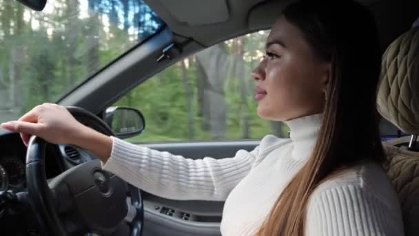 Jonge brunette vrouw besturen van een auto — Stockvideo