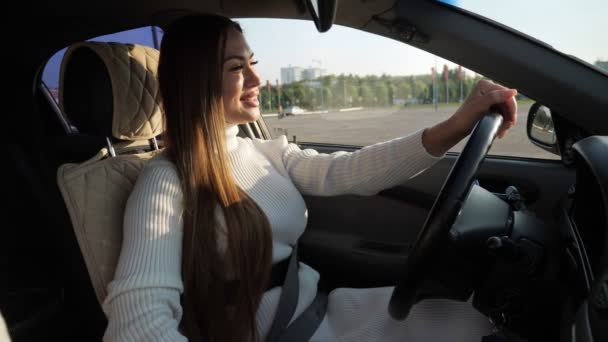 Mujer joven sonriente toma de la mano en el volante de cuero — Vídeo de stock