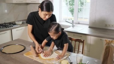 Genç bir kadın ve küçük bir kız tahtanın üzerinde para döşüyorlar.