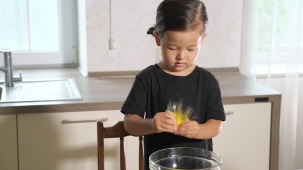 Divertido niño aprieta huevo que salpica en camisa negra — Vídeos de Stock